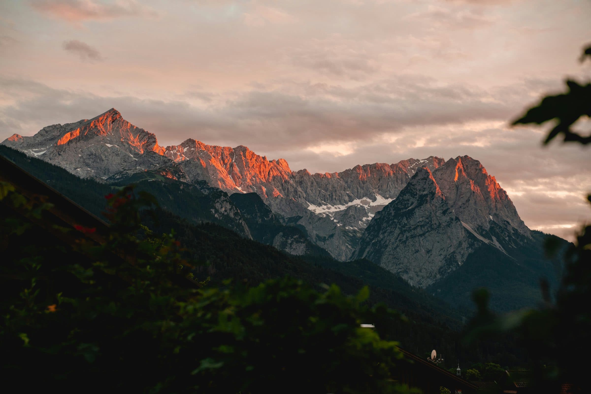 First light striking a mountain range while the valley below is still dark.